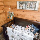 A cozy nursery scene featuring a wooden wall, pine paneling, and a baby crib covered with a soft blanket. Above the crib, a felt sea life mobile hangs from a wooden frame, suspended by strings. The overall atmosphere is serene and inviting.