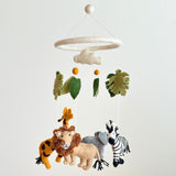 A felt baby mobile with a jungle safari theme, featuring a zebra, giraffe, and elephant hanging from it. The wool felt baby mobile is suspended in the air against a white background, showcasing its vibrant colors and intricate details.