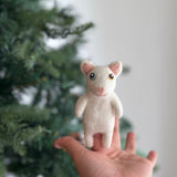 A female hand presents a handmade felt Van Cat finger puppet, "Titi", against a blurred, festive Christmas tree backdrop. This charming white felt puppet features distinct heterochromia with one captivating yellow eye and one blue eye, complemented by delicate pink inner ears. It is a unique handcrafted felt kids toy, perfect for imaginative storytelling.