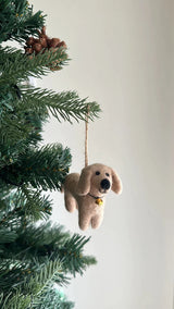 Felt dachshund ornaments hang from a green Christmas tree, set against a plain white background. Four adorable felt dachshunds in cream, khaki, brown, and black surround a playful felt bone on a white felt frame, creating a cheerful canine-themed Christmas tree ornament. Made from soft felt, it includes a jute string for easy hanging.