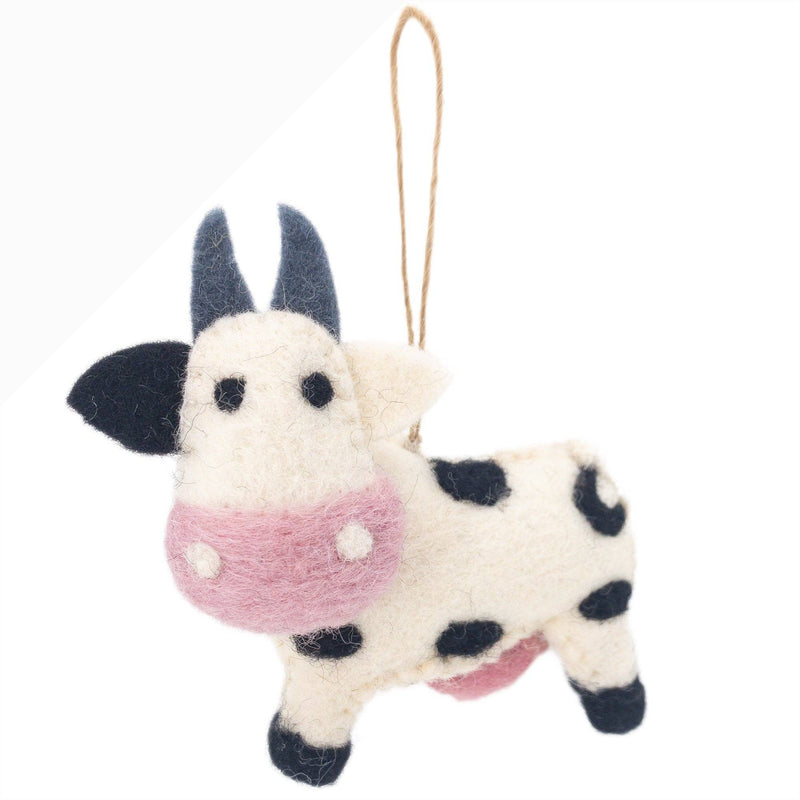 A single felt cow Christmas ornament, part of the Farmland Animals set, is displayed against a crisp white backdrop. This charming handcrafted felt ornament features a creamy white body with black spots, a soft pink snout, small black eyes, and gray felt horns. A jute string is attached for easy hanging, perfect for a Christmas tree.