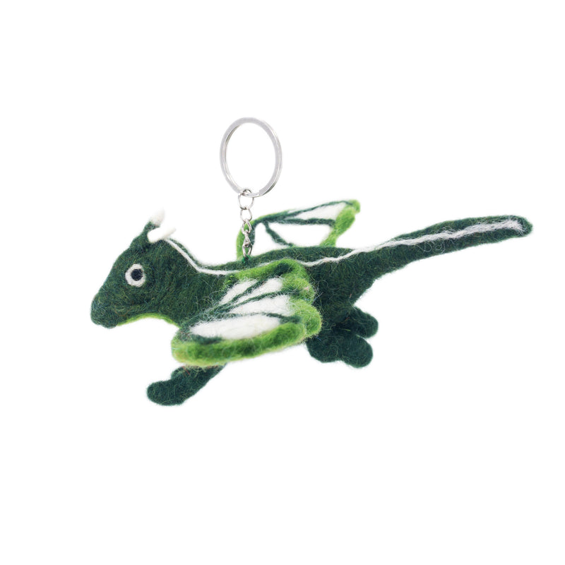 A needle felted flying dragon keychain, handcrafted and unique, is displayed against a stark white backdrop. This whimsical green dragon features a rounded body, pointed tail, small stubby legs, and dual-toned green and white wings. It has small white horns and a metal keychain with a clasp attached to its top.