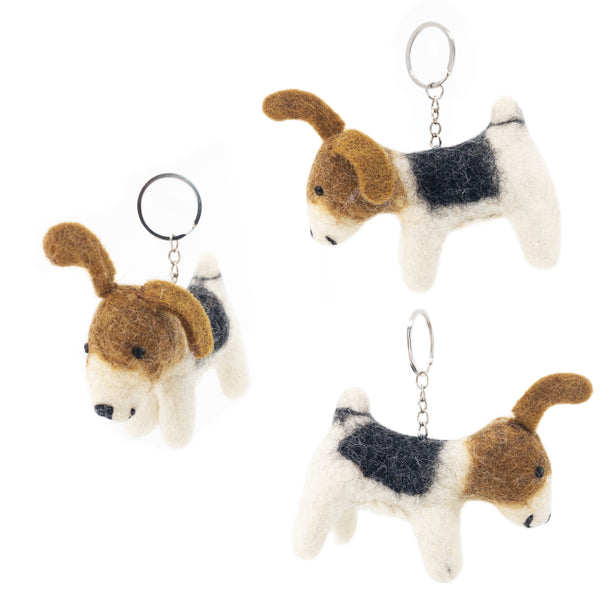 Three handmade Jack Russell felt keychains are suspended against a stark white background, creating a cheerful, floating display. Each charming keychain features a metal clasp and a round, felted Jack Russell dog with perky ears, white fur, and distinctive brown and black markings, highlighting their handcrafted details.