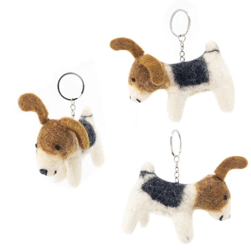 Three handmade Jack Russell felt keychains are suspended against a stark white background, creating a cheerful, floating display. Each charming keychain features a metal clasp and a round, felted Jack Russell dog with perky ears, white fur, and distinctive brown and black markings, highlighting their handcrafted details.