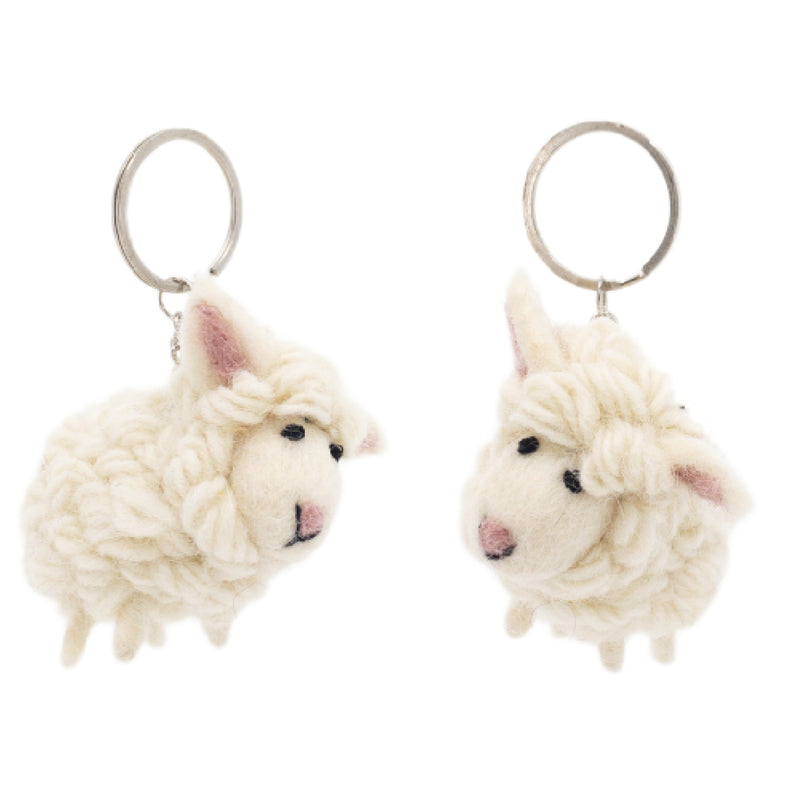 Two off-white wool felt sheep keychains are displayed against a bright white backdrop. Each mini sheep keychain is crafted from textured 100% wool felt, resembling a fluffy coat, with small black eyes and pink felt in their ears. They each feature a metal ring with a clasp for easy attachment.