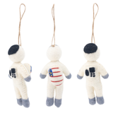 A handmade felt astronaut ornament is displayed against a bright white background, shown from three distinct angles: side, front, and back. This needle felted ornament features a white body with grey extremities and a black rounded square on the head. A flag graphic appears on the front chest and right arm, while the back displays a black square design.