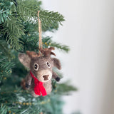 A cute Christmas Reindeer felt ornament hangs from a festive Christmas tree. This charming felted reindeer ornament features a light gray body, a dark brown nose, small antlers, and a bright red scarf, suspended by a jute string amidst the green needles and string lights.