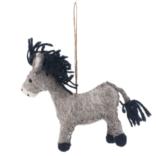 A handmade felt donkey ornament, crafted from New Zealand wool felt, is suspended by a jute string against a stark white backdrop. The gray donkey features a textured body with black accents on its hooves, mane, and tail. It has pointed ears and a simplistic face with subtle eye and nostril details.