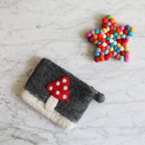 A vibrant star felt coaster rests on a bright marble backdrop. This handcrafted felt coaster, made from colorful, hand-stitched organic lamb wool felt balls, forms a playful patchwork of cheerful hues. Its unique design creates a cozy and inviting atmosphere, reflecting the ethical craftsmanship of Nepalese female artisans.