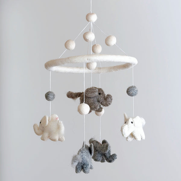 A hanging wool felt baby mobile, featuring a central circular frame suspended from which several soft, textured felt sea creatures are attached. A small elephant figure is positioned at the bottom center of the mobile.